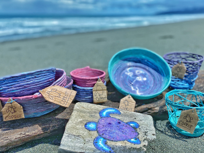Recycled plastic products lie on the beach for display.